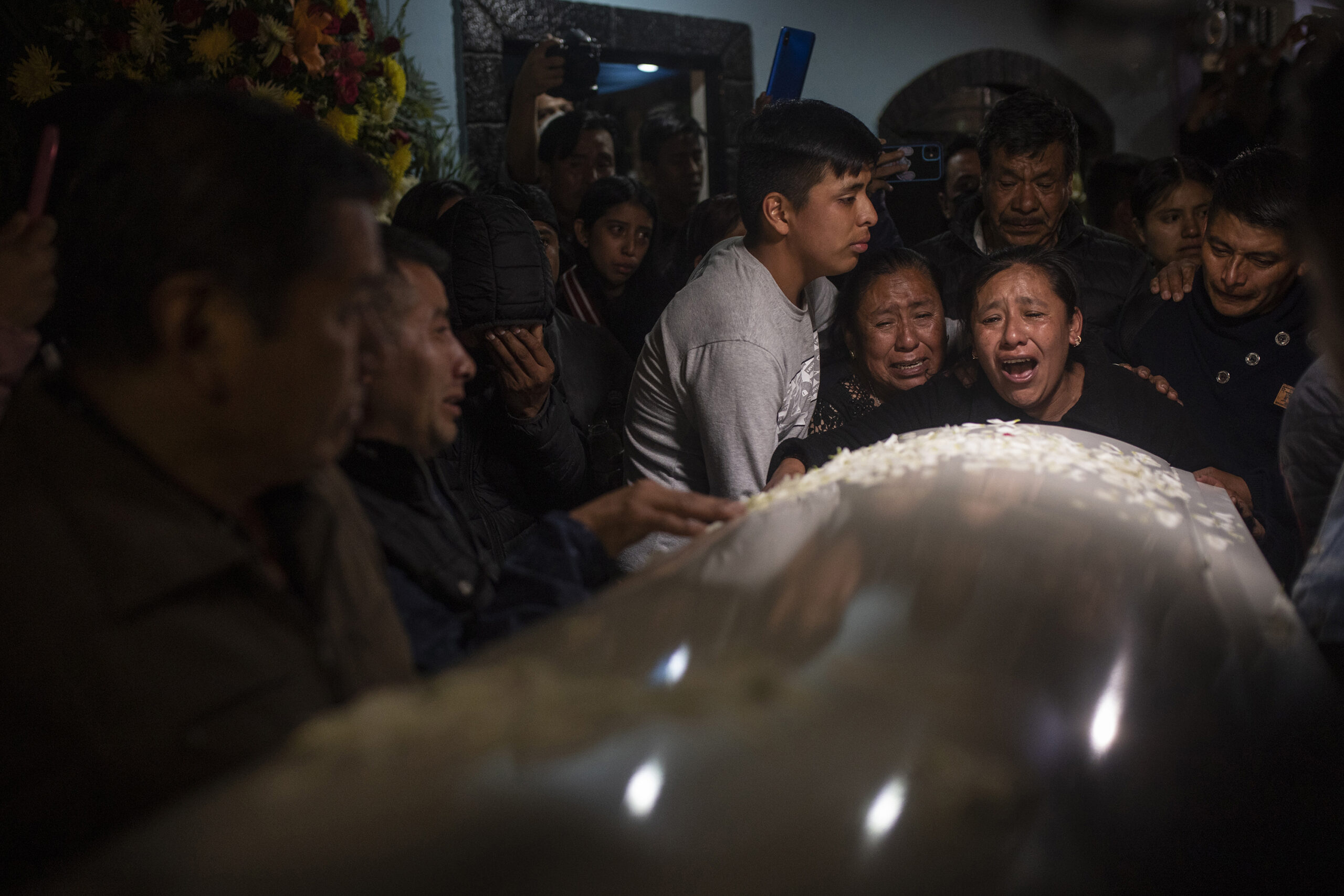 Relatives and friends react as the bodies of Jair Valencia, Misael Olivares, and Yovani Valencia arrive to their family house in San Marcos Atexquilapan, Veracruz, Mexico on July 13, 2022. The three were among a group of migrants who died of heat and dehydration in a locked trailer-truck abandoned by smugglers on the outskirts of San Antonio, Texas, on June 27.