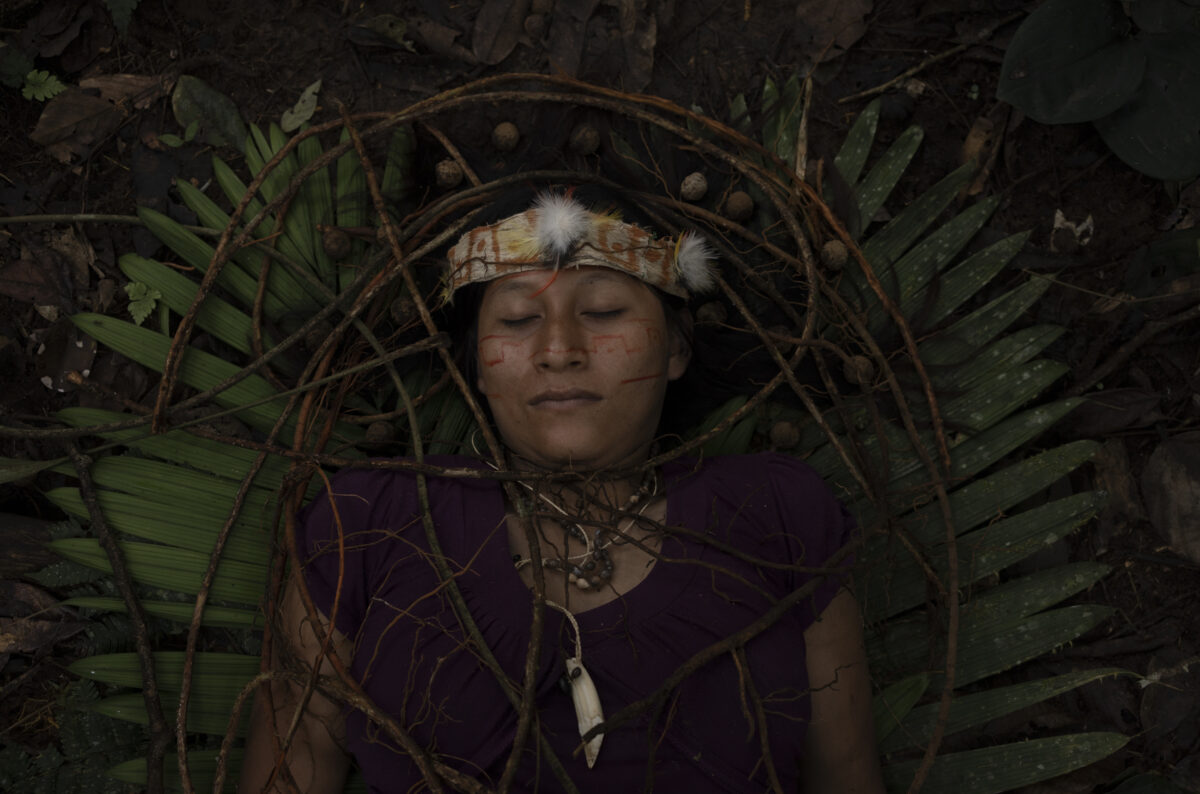 Swicha Grefa lays on the land covered in lianas, as she poses for a portrait in the Atatakuinjia community, Sapara territory in the Ecuadorian Amazon rainforest on July 7, 2022.