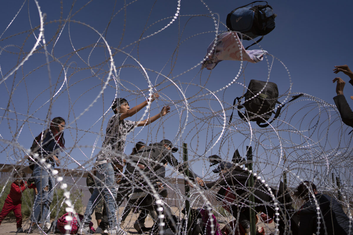 CIUDAD JUÁREZ, MEXICO - MAY 11: Hours before Title 42 is set to expire, migrants from Colombia and Mexico throw their bags over razor wire fencing after crawling through an opening in order to turn themselves into U.S. Customs and Border Protection agents who are posted along the border wall between El Paso, United States and Ciudad Juárez, Mexico on May 11, 2023.  

Title 42 is a public health policy first used by the Trump administration to deter the spread of COVID-19 in the U.S. and expanded under Biden’s presidency. (Photo by Danielle Villasana for The Washington Post)